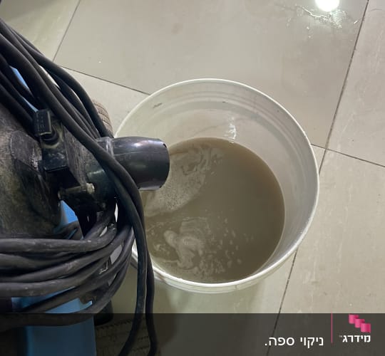 דלי עם מים מלוכלכים ומכונת ניקוי על רצפה